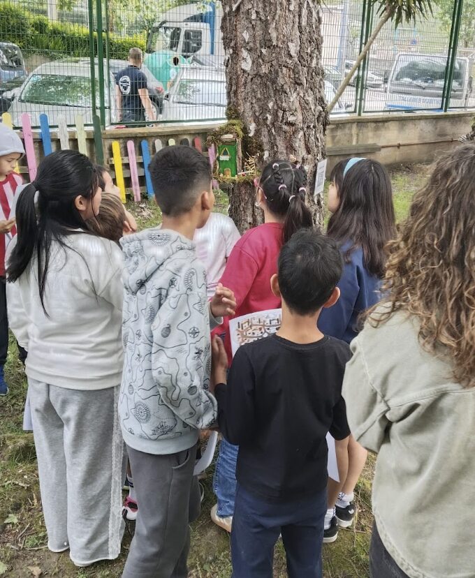 En esta imagen se ven unos niños acercándose a observar a una caseta que esta situada en un árbol.