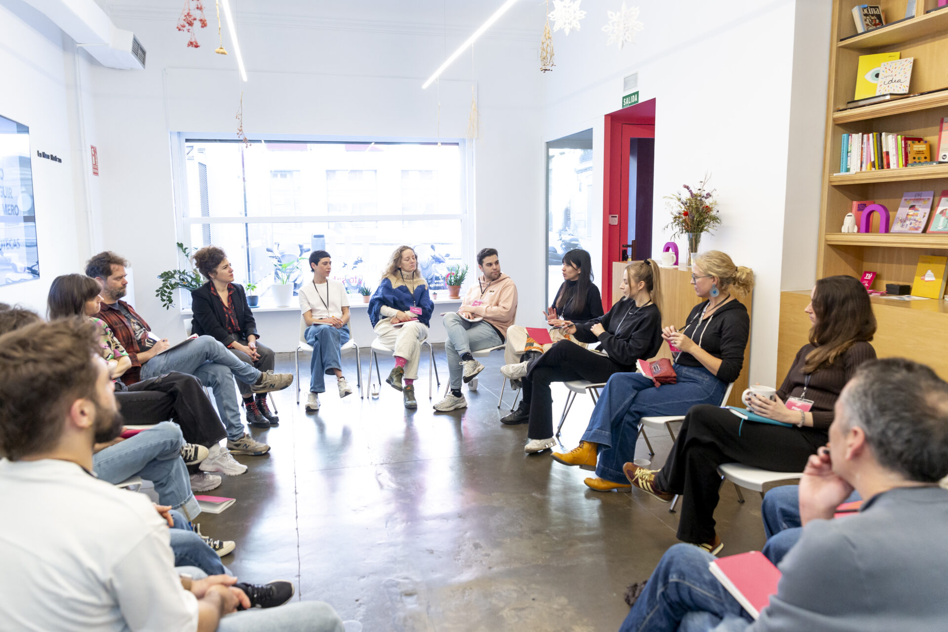 Personas sentadas en círculo con Alex Filiatreau en el fondo.