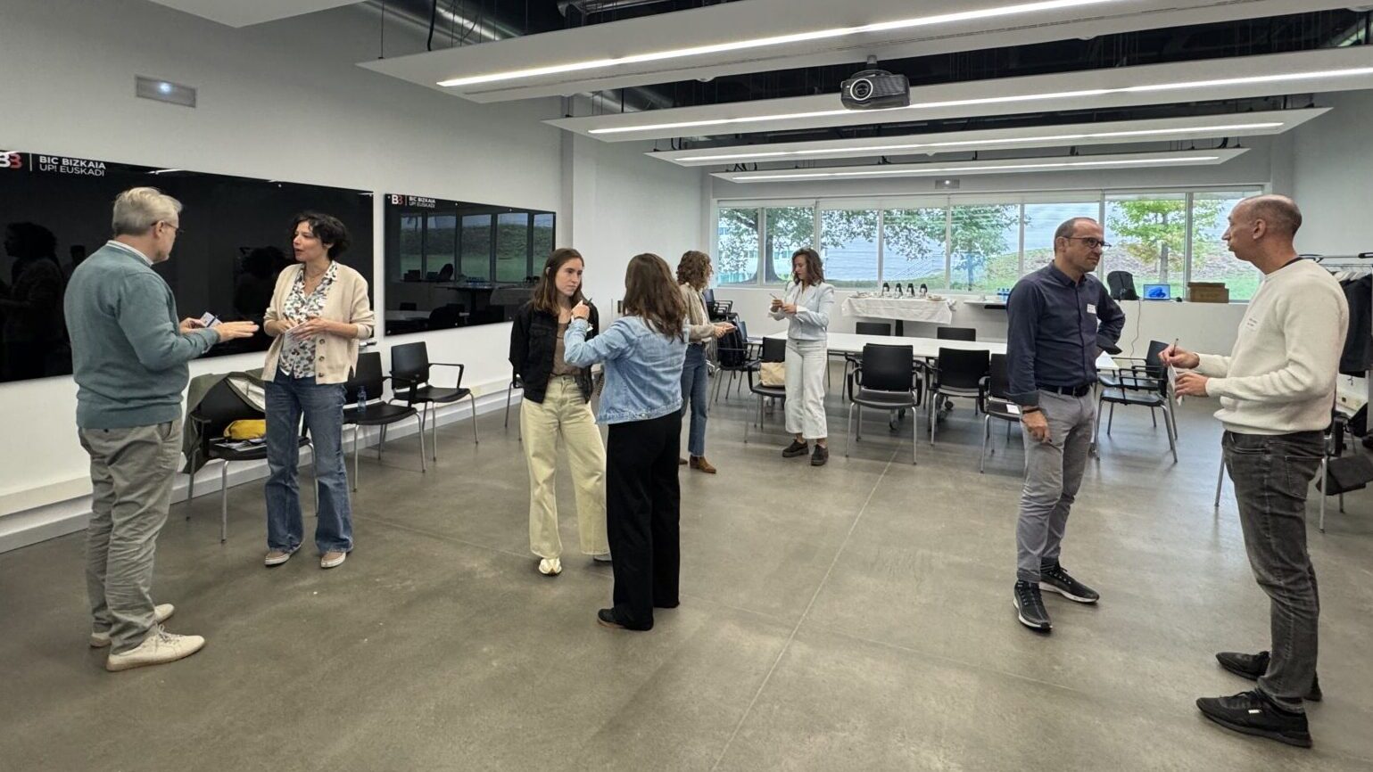 Personas de pie hablando en parejas.