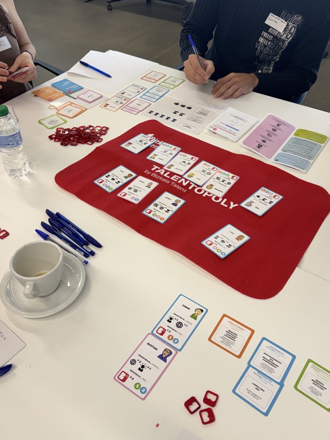 Personas alrededor de una mesa jugando a un juego creado "Talentopoly".