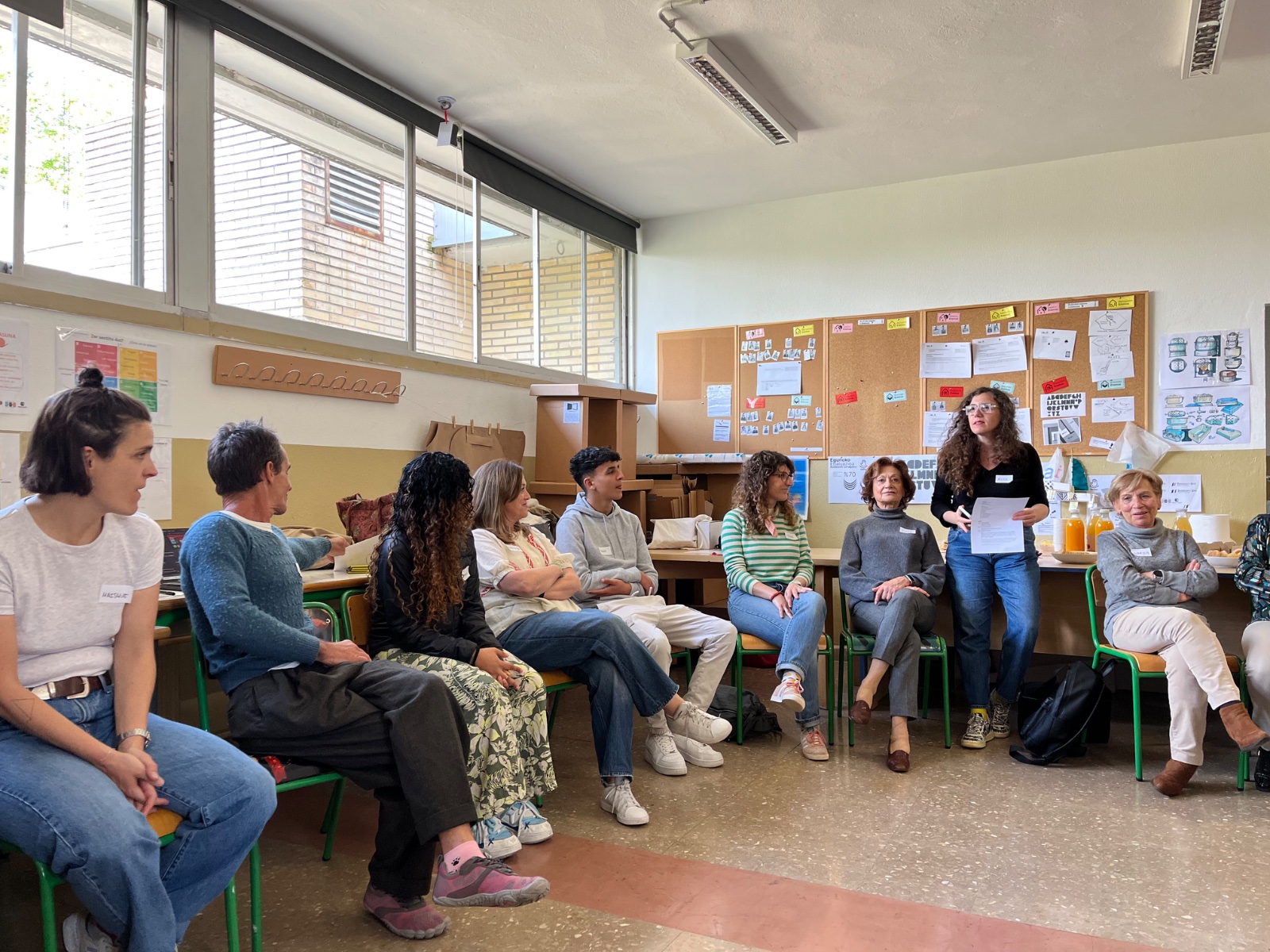 Personas sentadas en un circulo teniendo una reunión de Bizi Bitxi. 